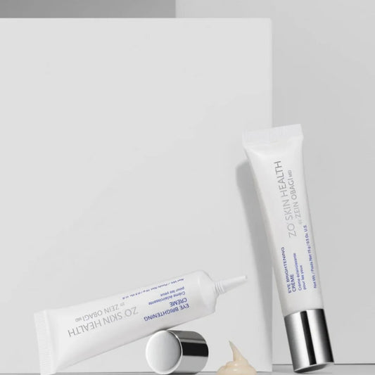 ZO Skin Health eye brightening creme tubes with silver caps and cream dollop on white background