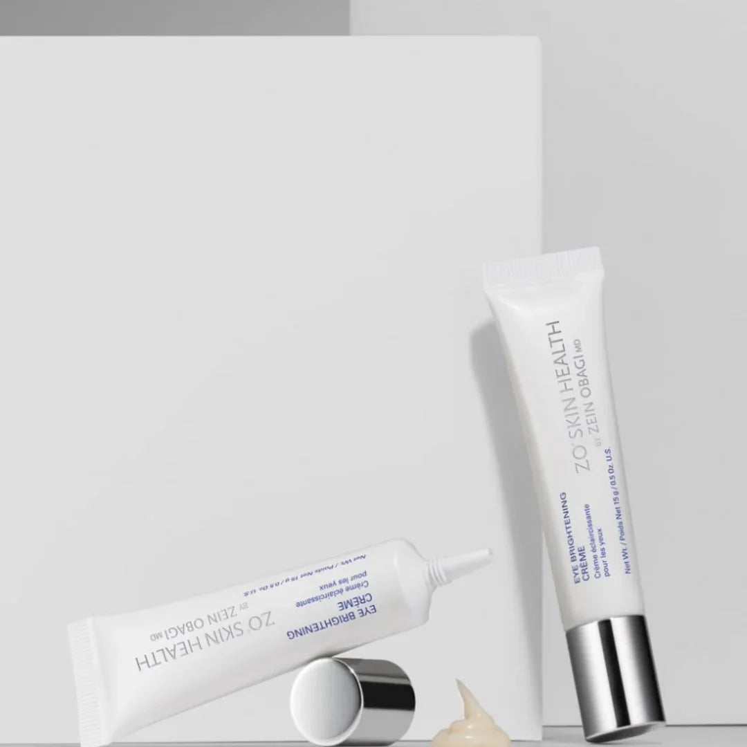 ZO Skin Health eye brightening creme tubes with silver caps and cream dollop on white background