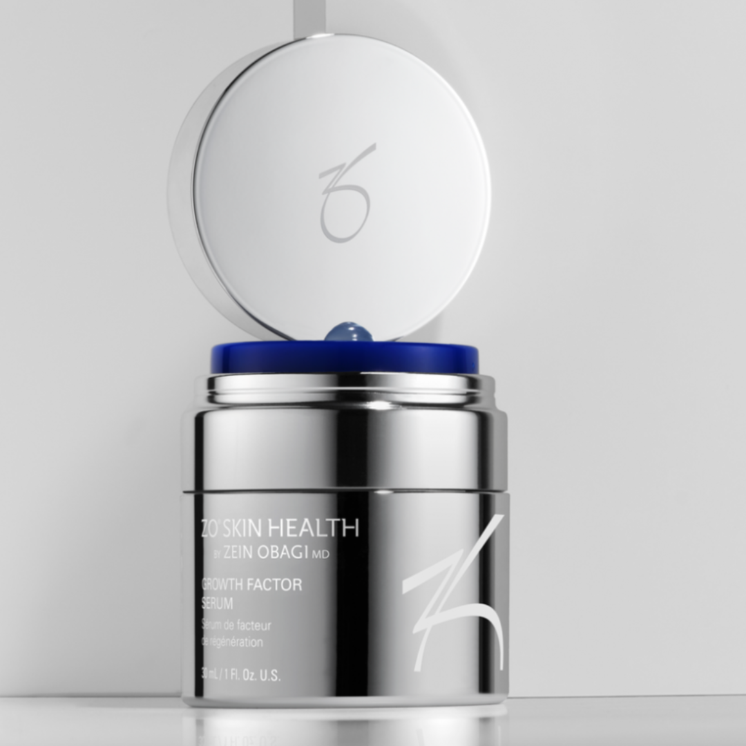 ZO Skin Health Growth Factor Serum in reflective silver jar with open lid and blue serum drop